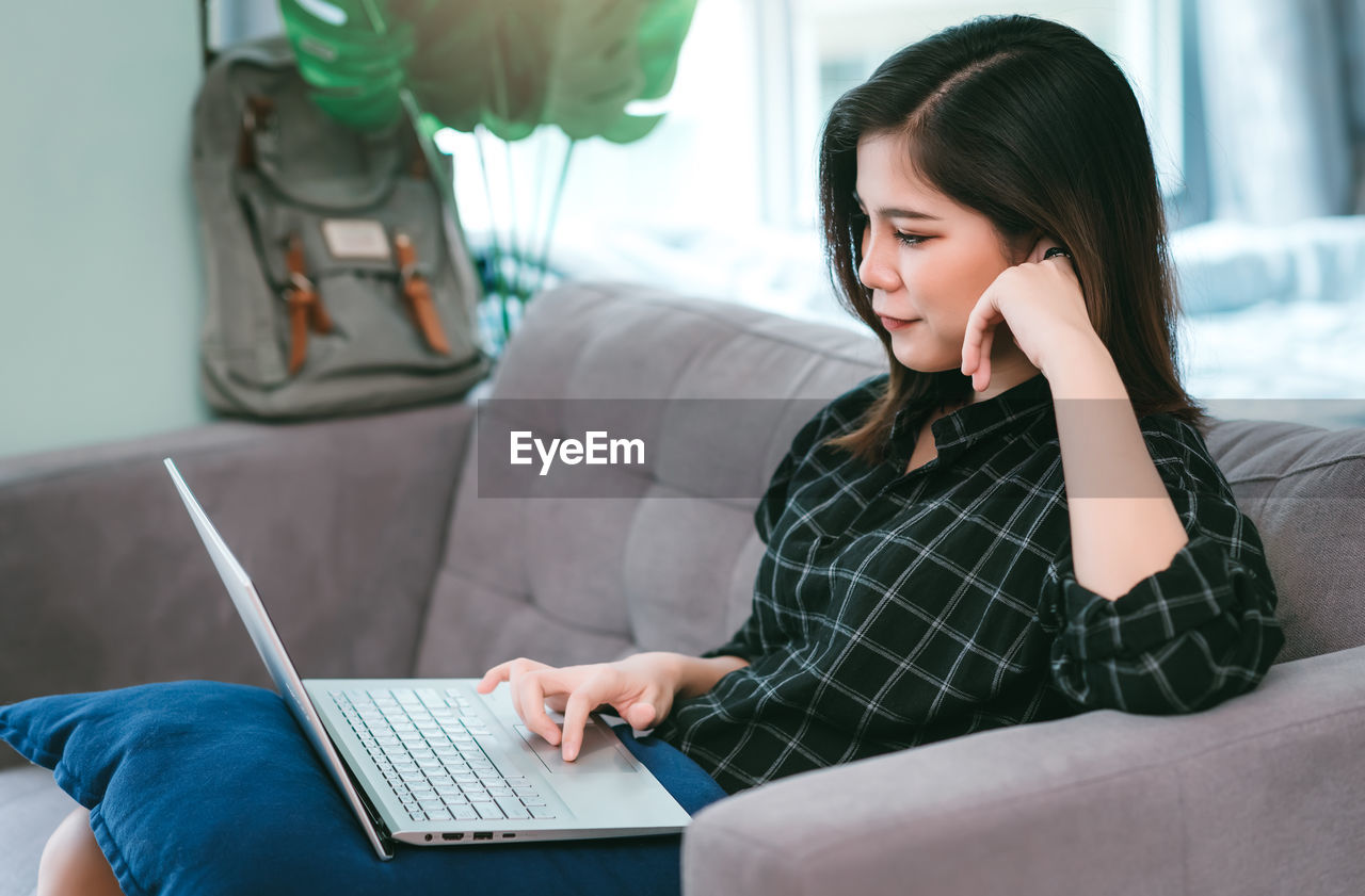 Young woman using laptop at home