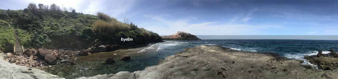 Panoramic shot of rocks on beach against sky