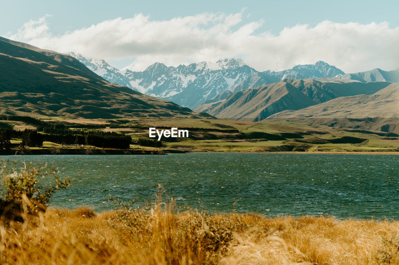 Scenic view of sea and mountains against sky