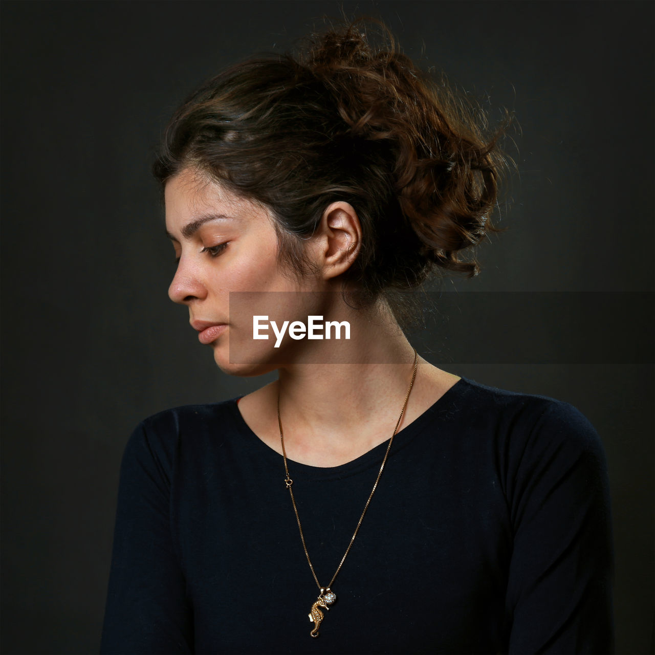 Thoughtful woman against black background