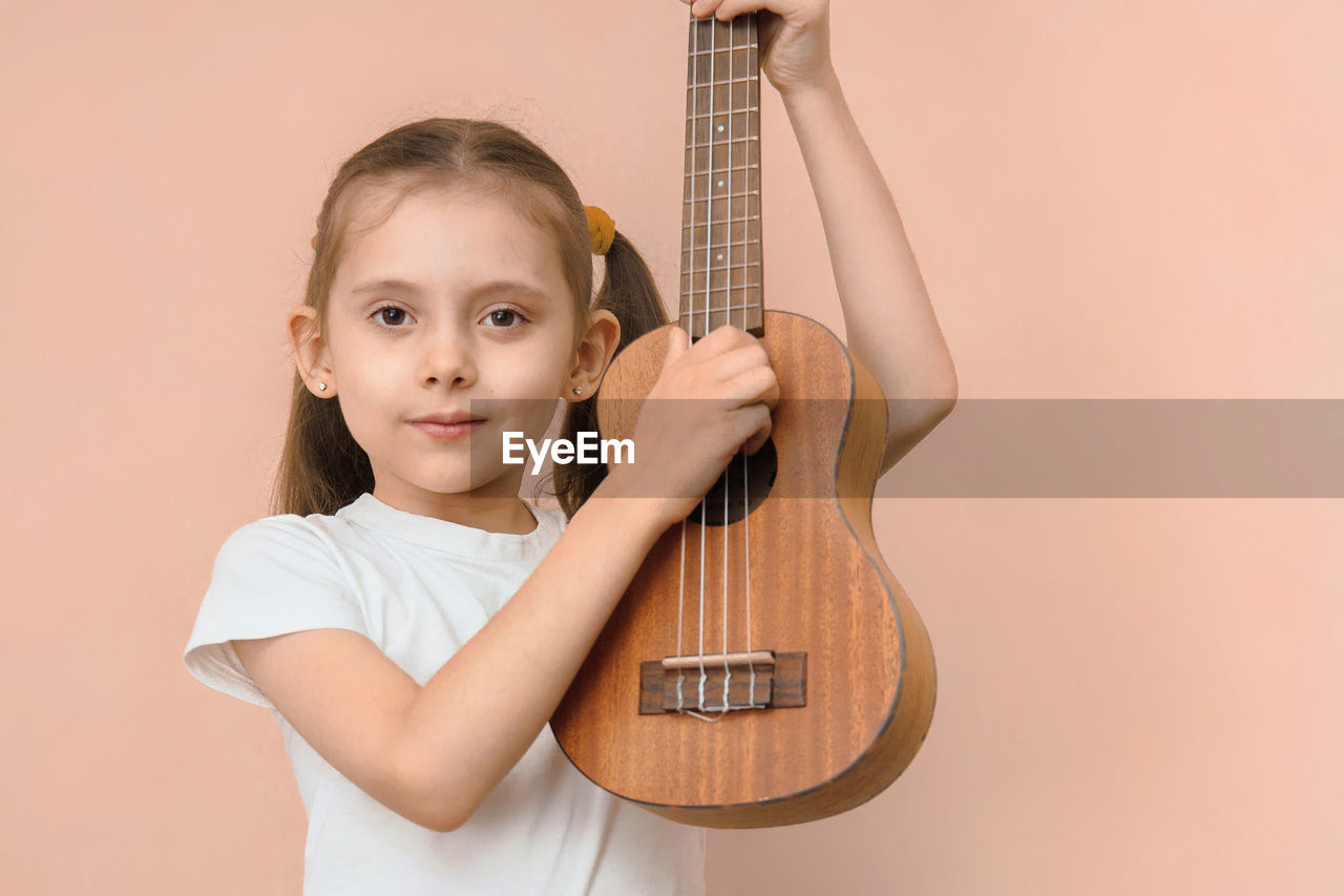 portrait of cute girl playing guitar