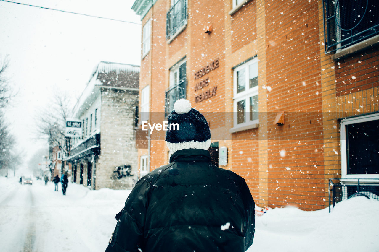 Rear view of man on snow in city