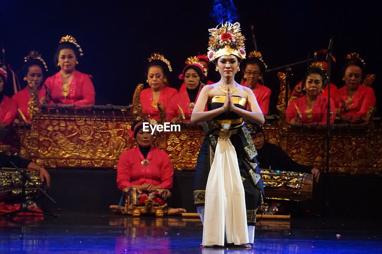 GROUP OF PEOPLE IN TRADITIONAL CLOTHING DURING NIGHT