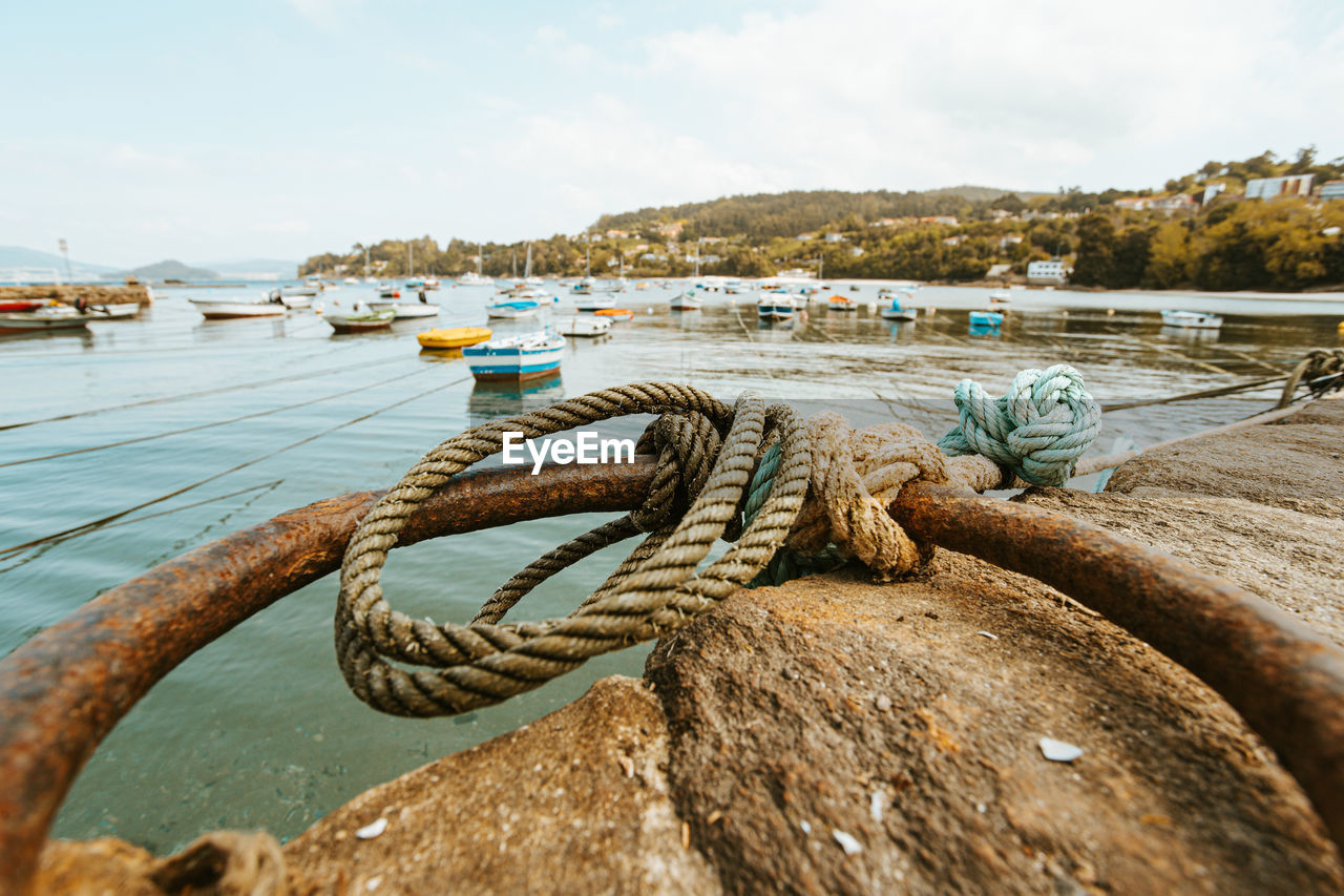 CLOSE-UP OF ROPE TIED TO BOAT