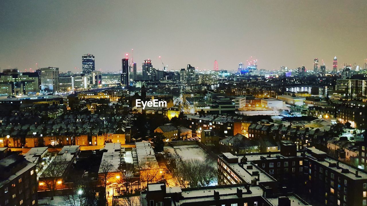 HIGH ANGLE VIEW OF ILLUMINATED CITY AT NIGHT