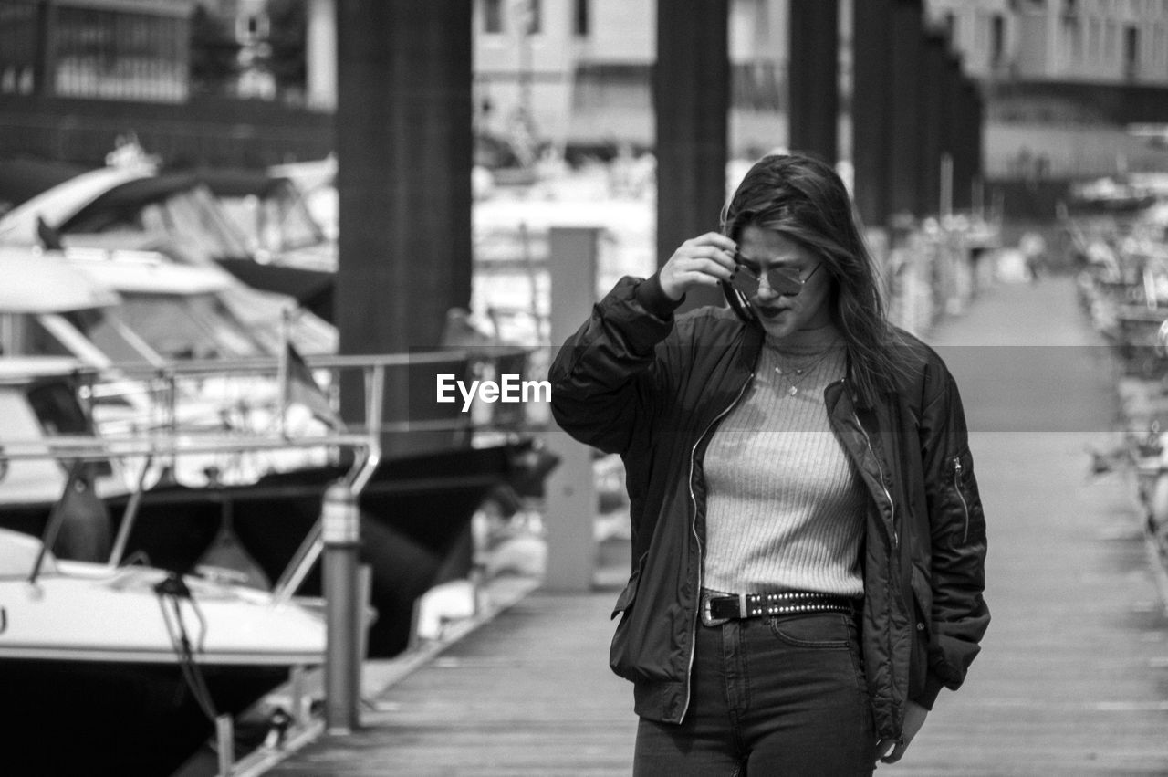 Woman in sunglasses walking on pier