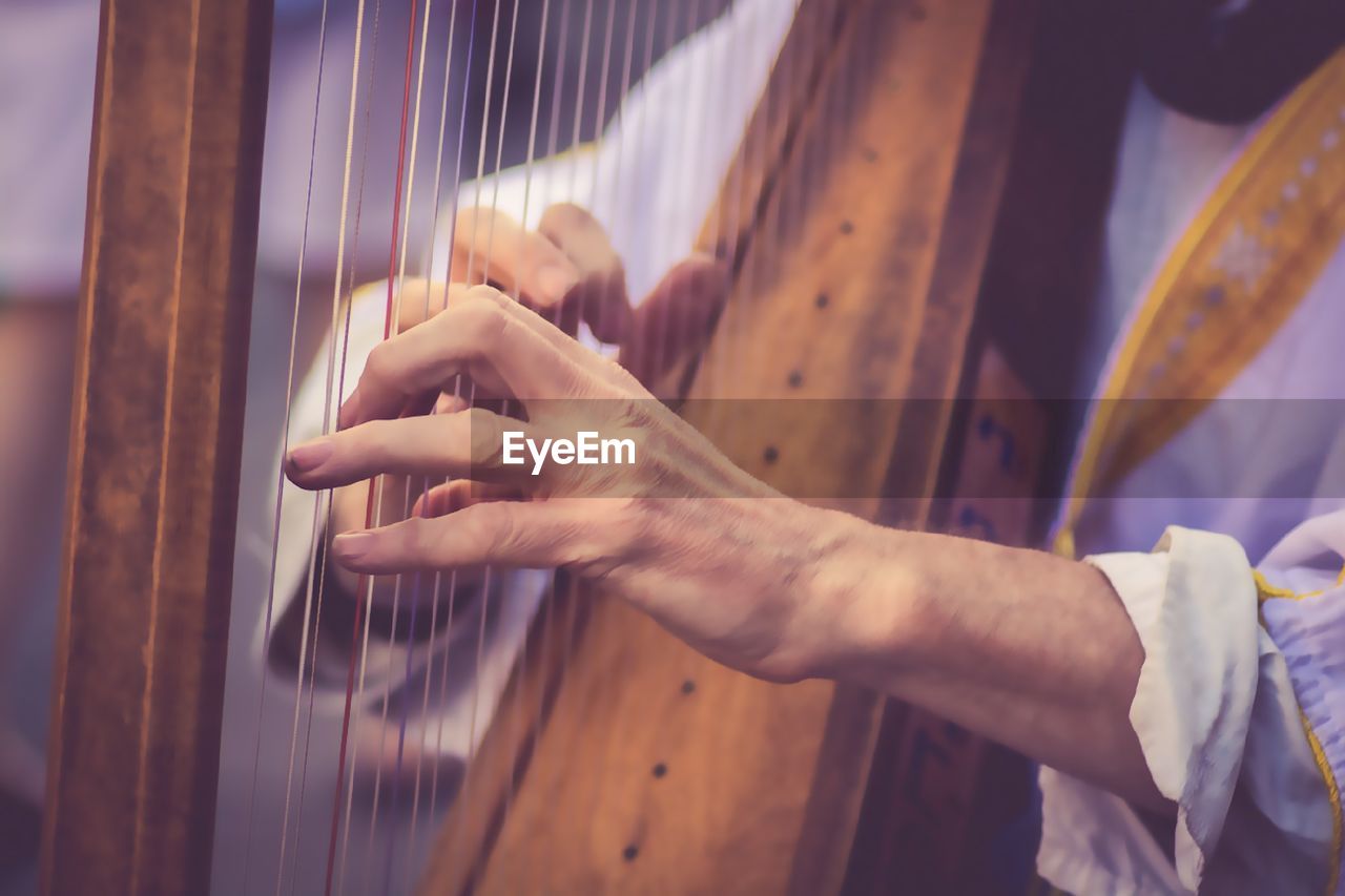 Midsection of man playing musical equipment