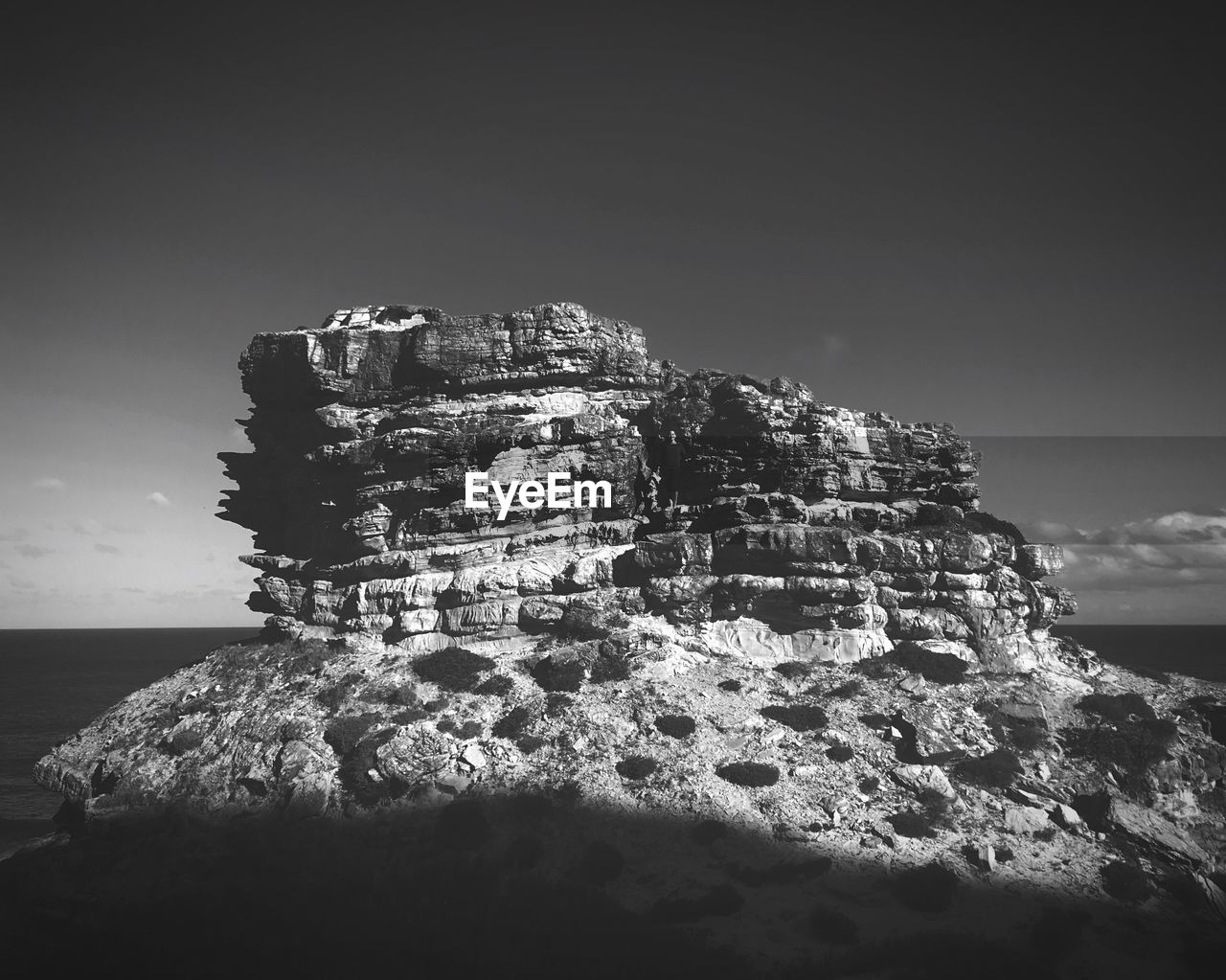 Rock formation on beach against sky