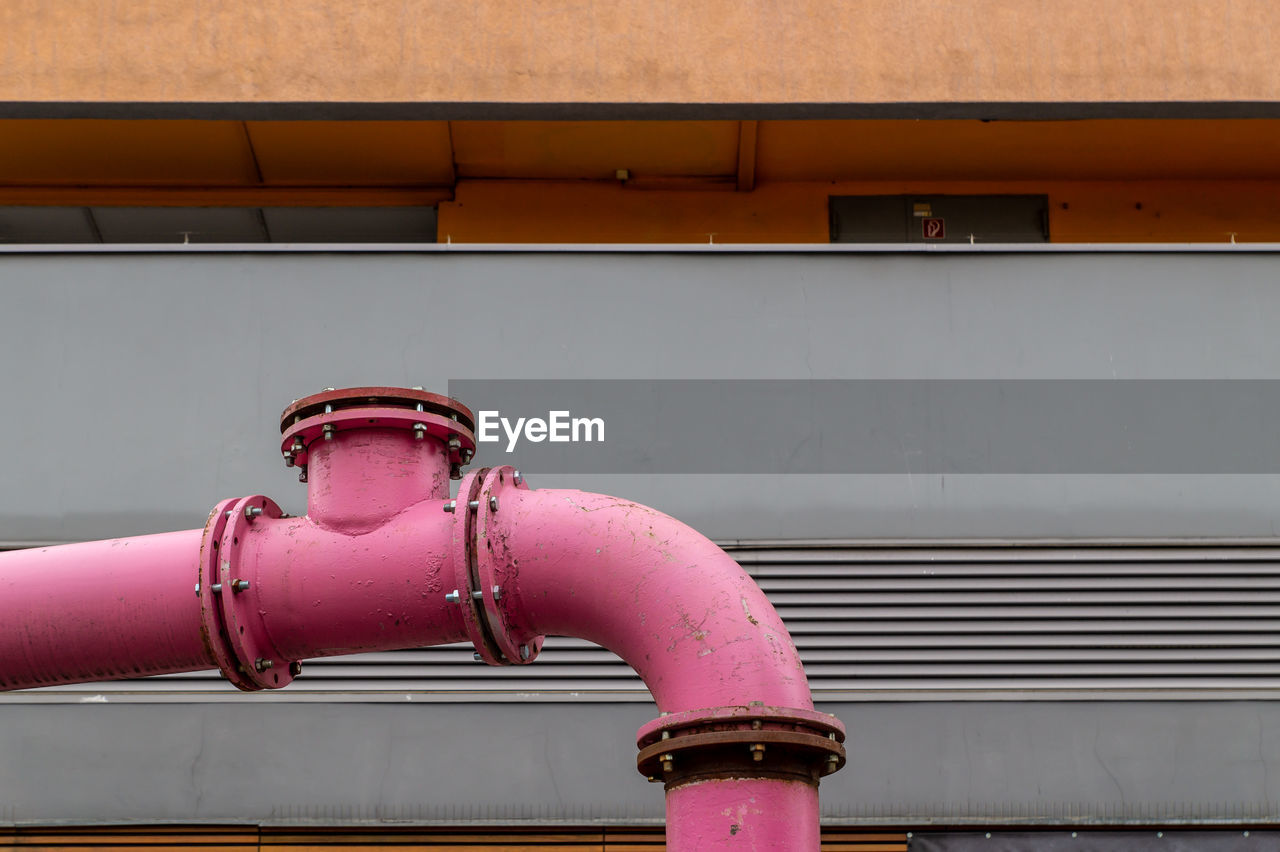 Close-up of fire hydrant against wall