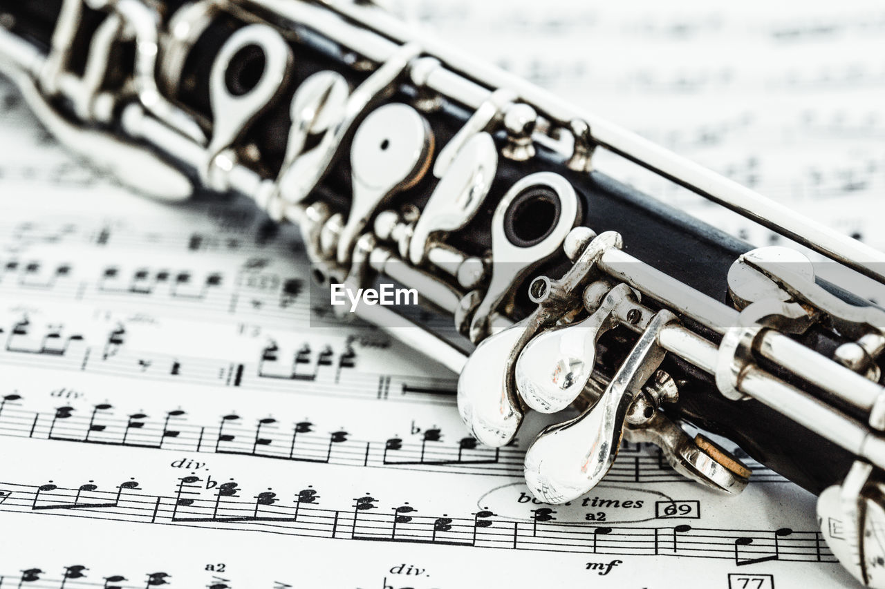 Close-up of woodwind instrument on sheet music