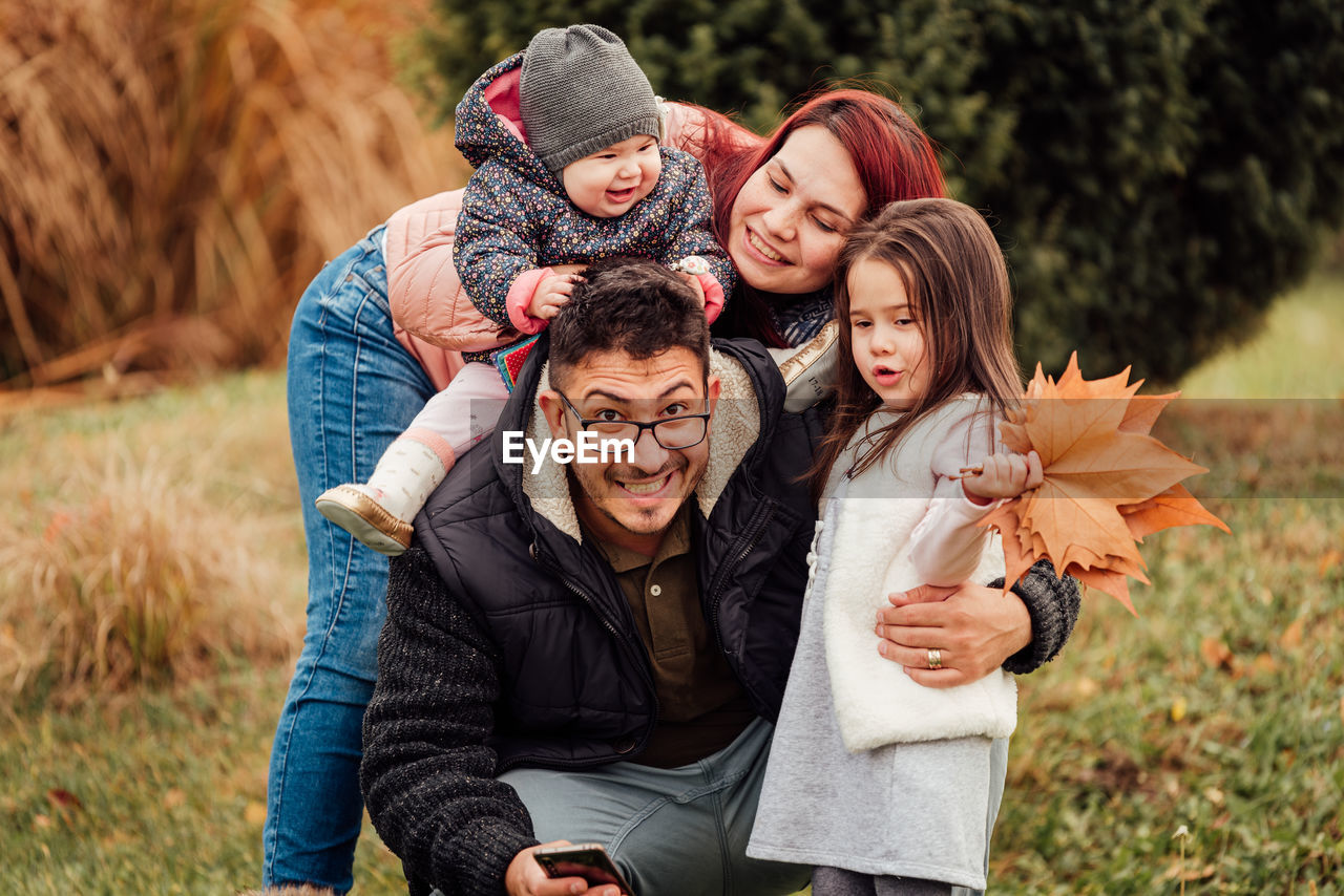 Young family with two children playing, laughing and smiling outdoors, after the covid-19 quarantine