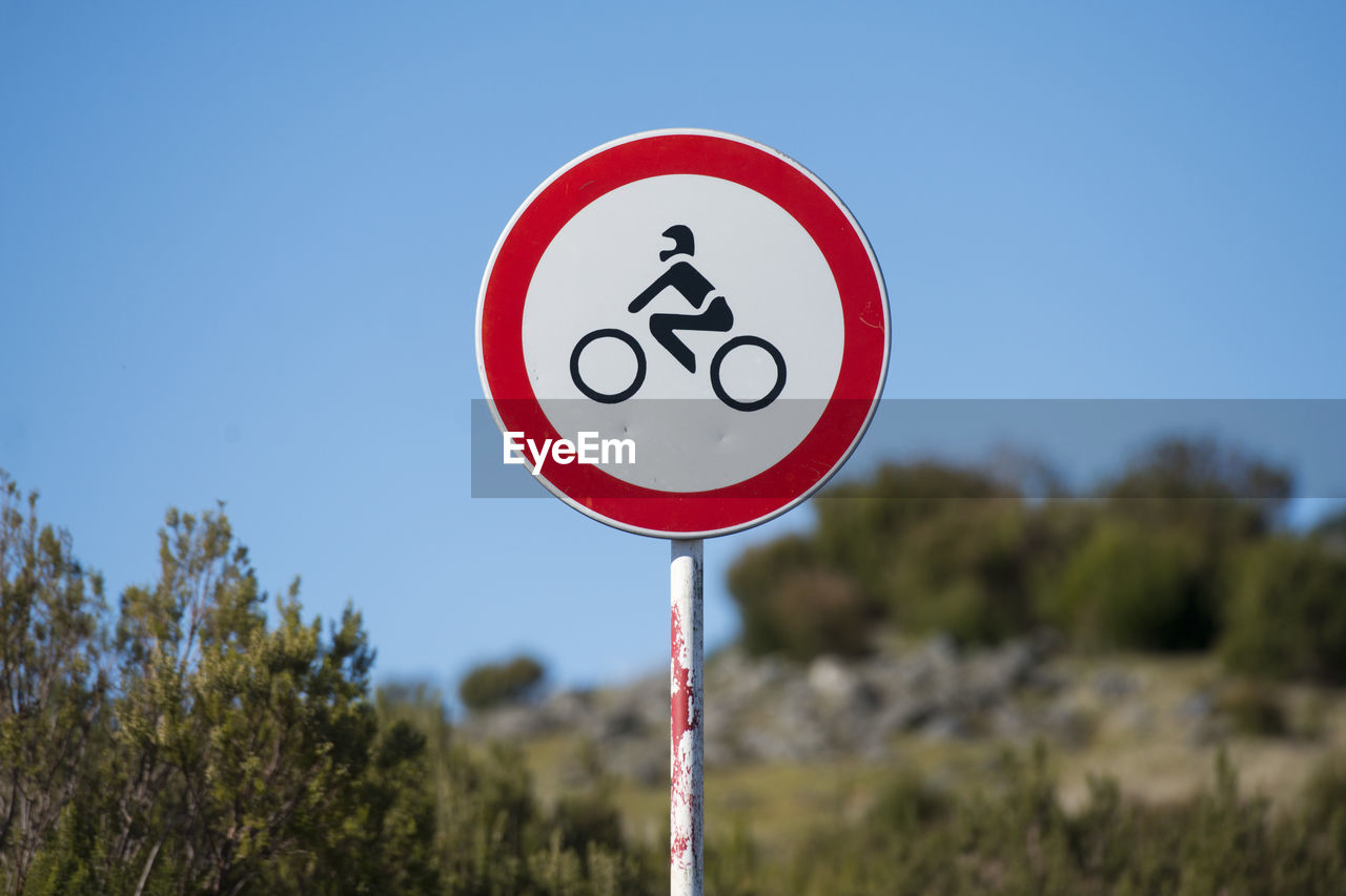 CLOSE-UP OF ROAD SIGN AGAINST SKY