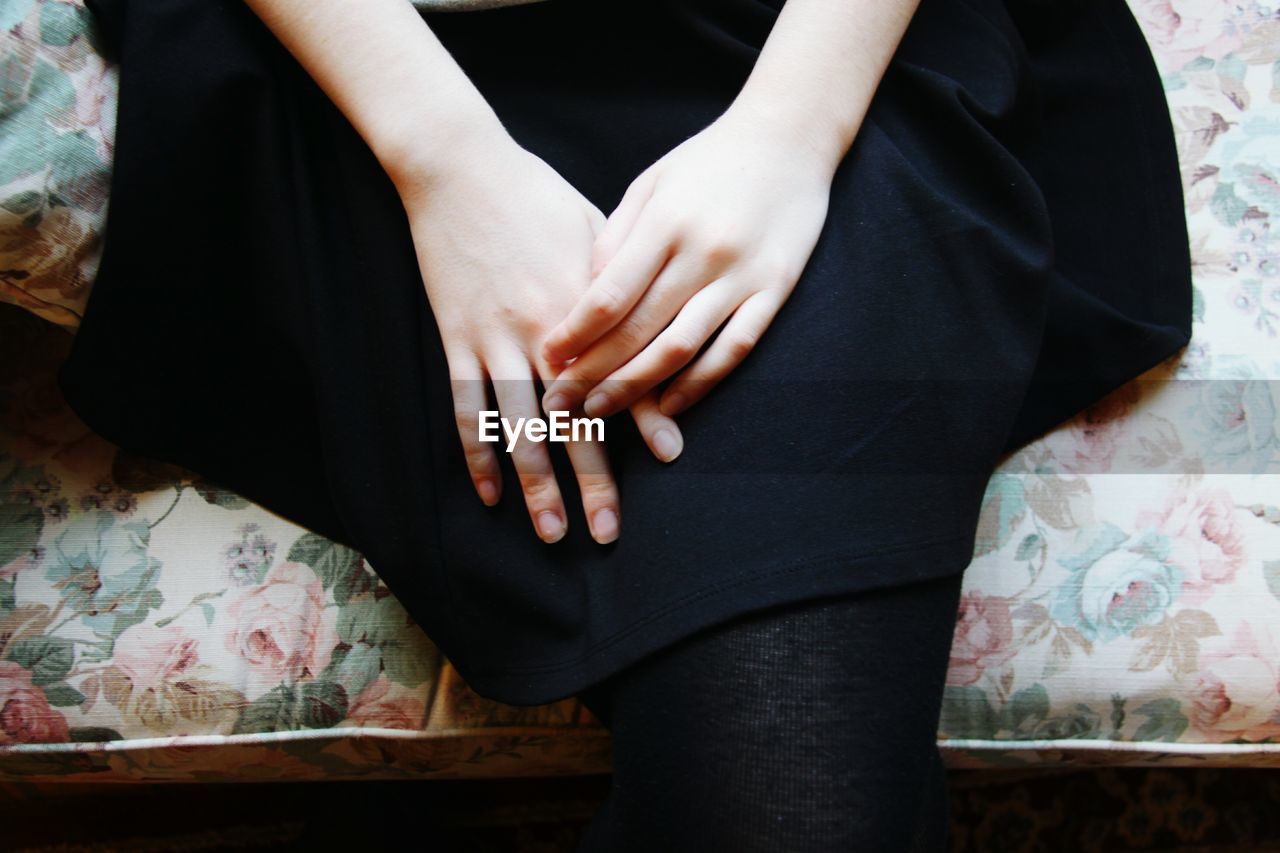 High angle view of hands of a young woman on lap