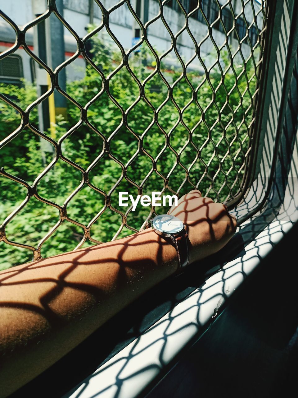 CLOSE-UP OF WOMAN BY CHAINLINK FENCE