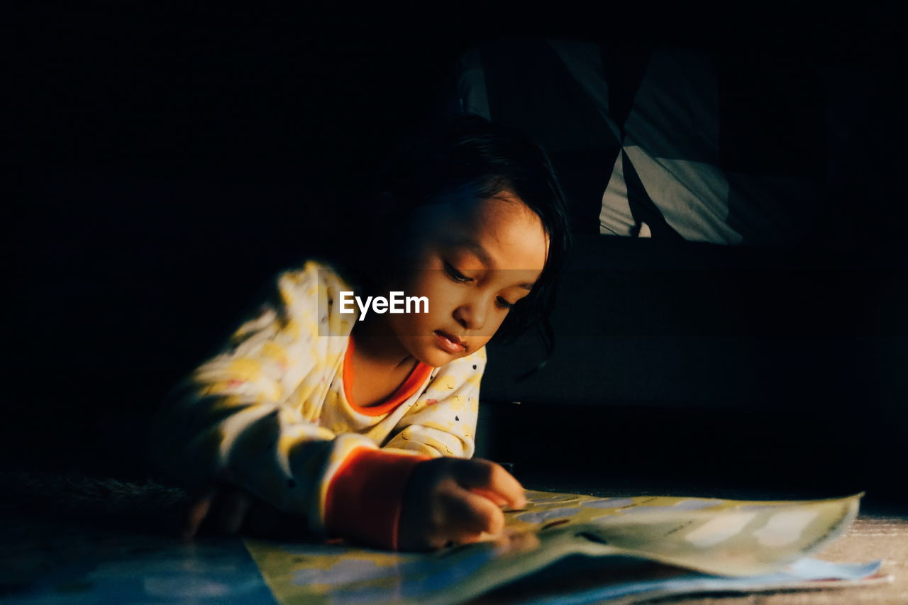 Cute girl playing with stickers at home