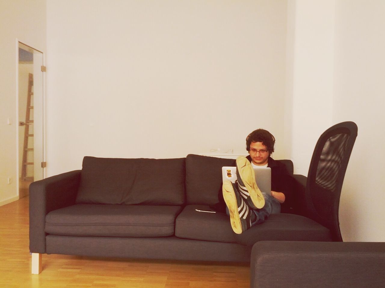 Young man using laptop on couch at living room