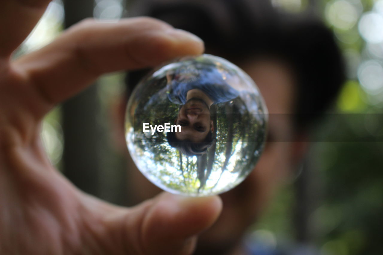 Close-up of hand holding crystal ball