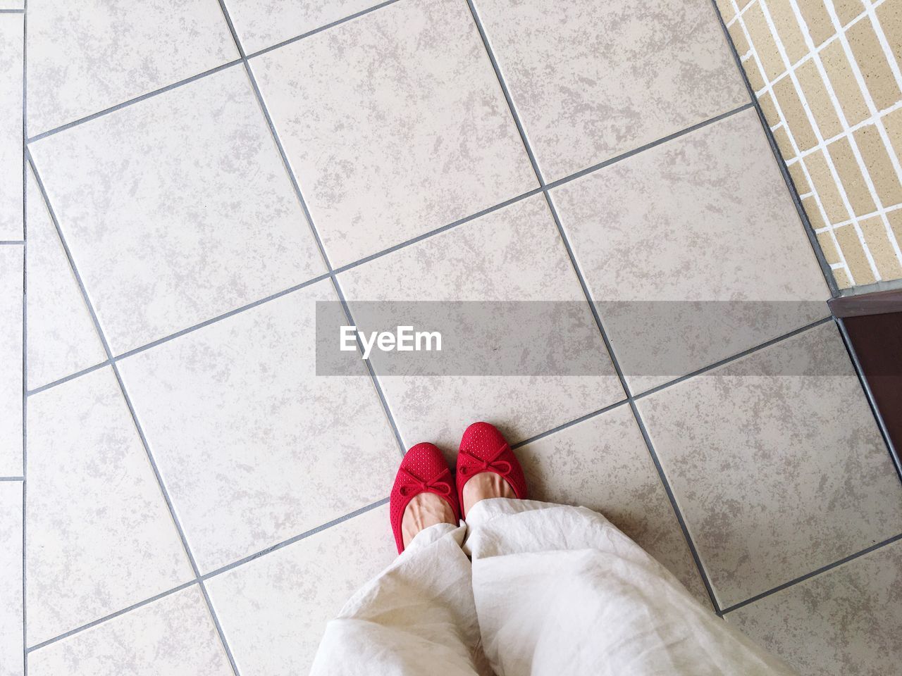 Low section of woman standing on tiled floor