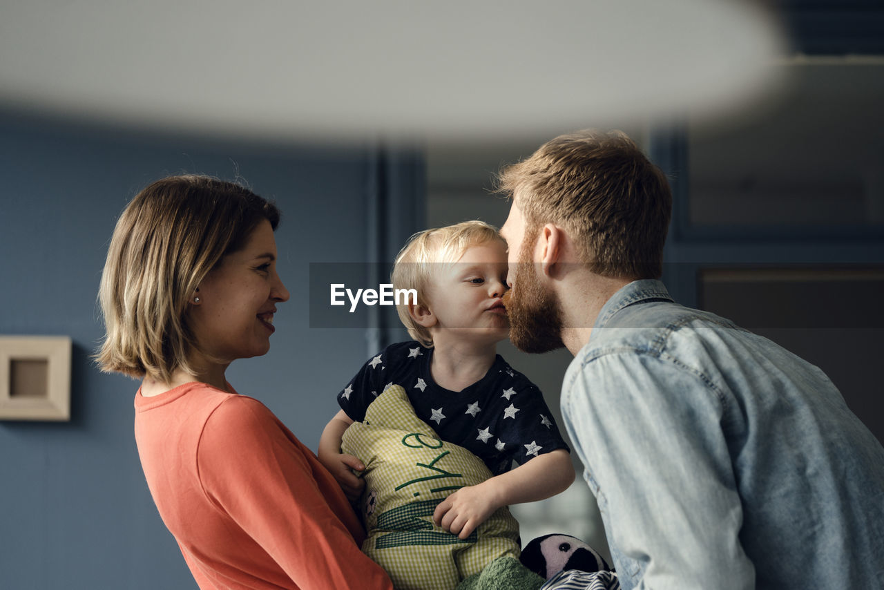 Happy family playing with their son at home