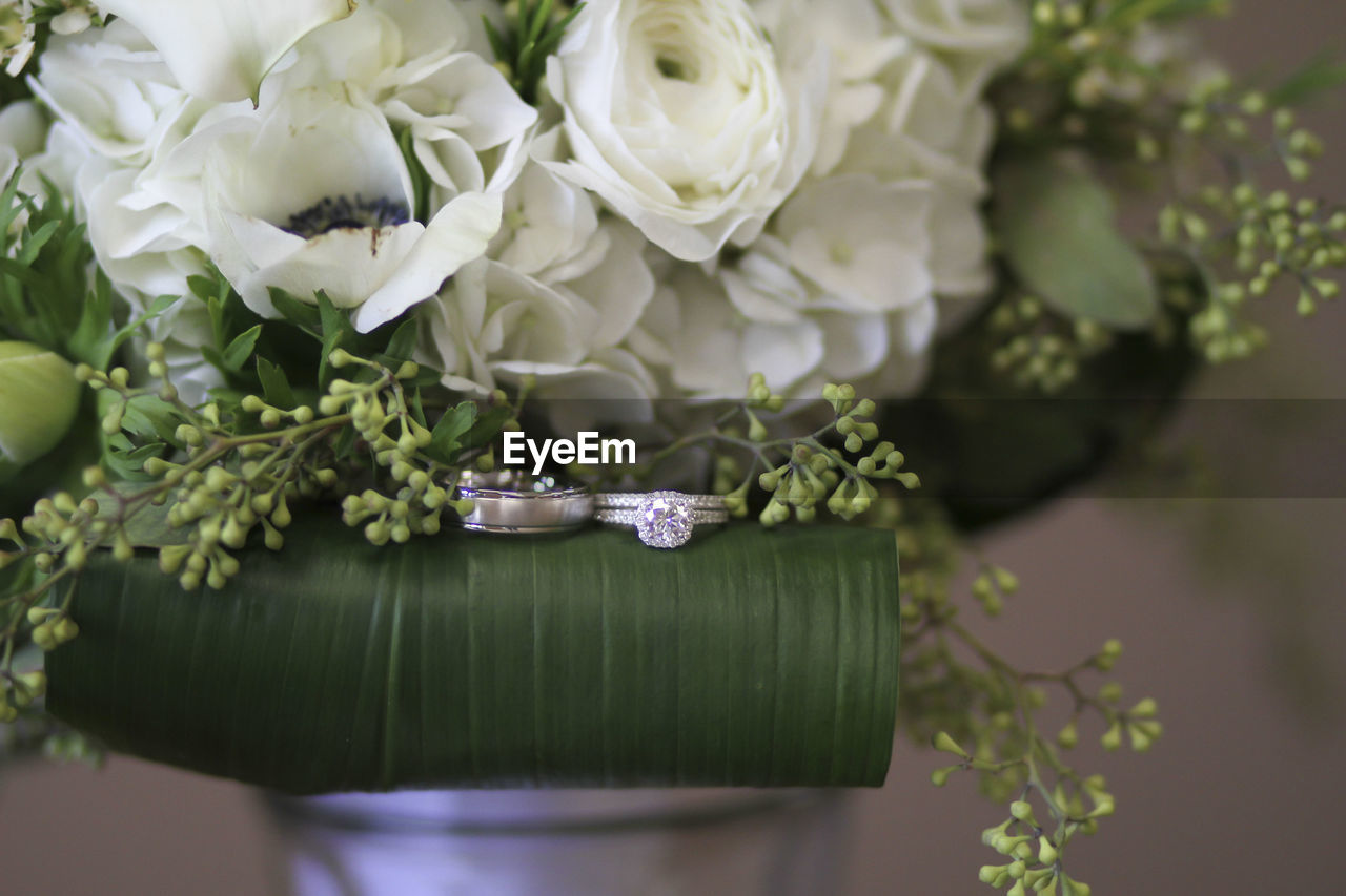 Close-up of rose bouquet and wedding rings