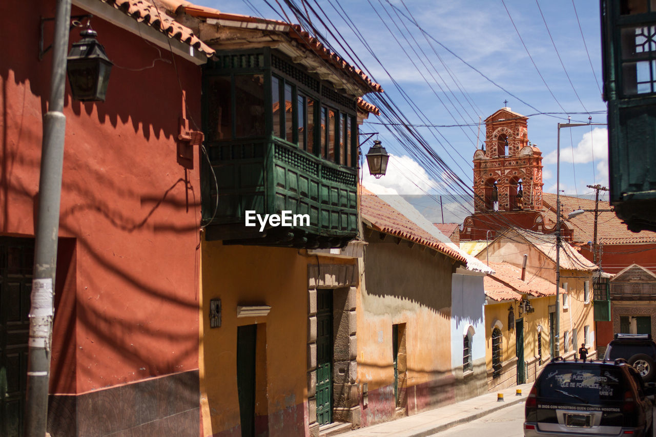 Cars on street amidst buildings in town, potosi bolivia. colonial architecture 