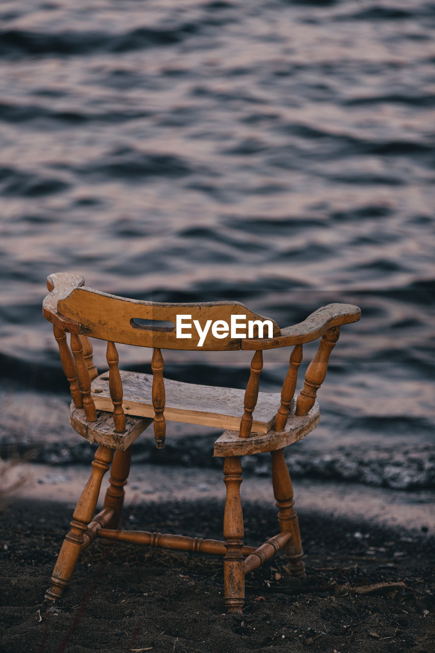 Wooden chair on sandy beach.