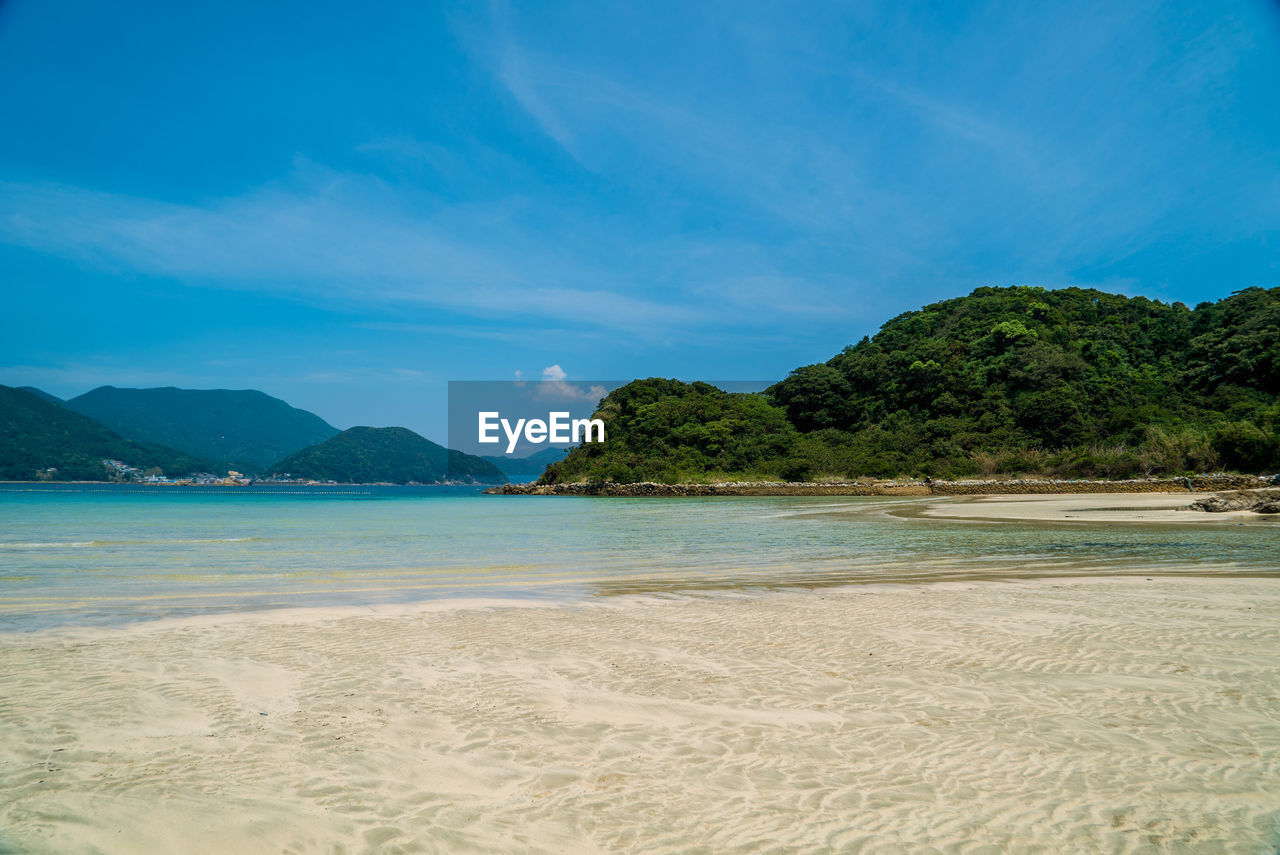 Scenic view of beach against blue sky