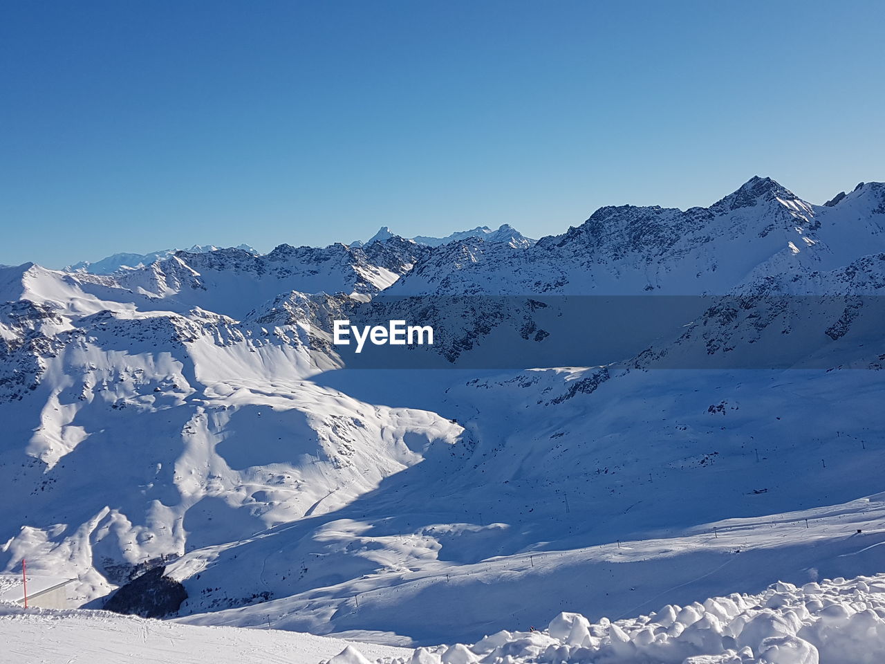 Scenic view of snowcapped mountains against clear blue sky