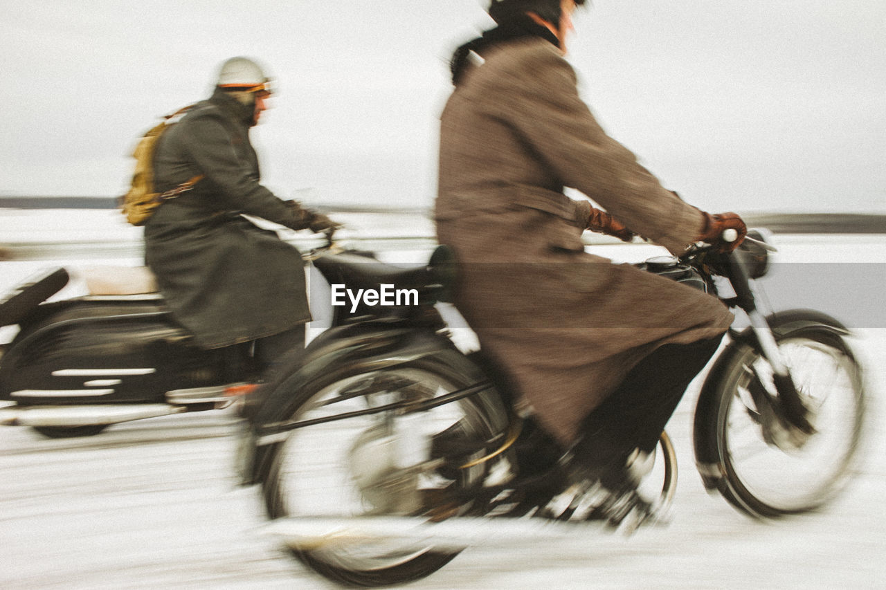 Side view of man riding bicycle on street