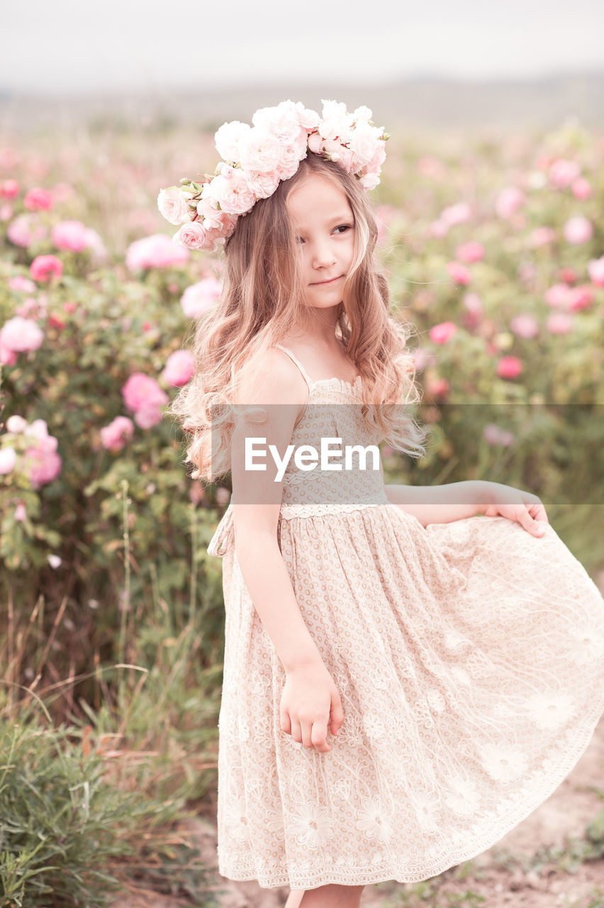 Cute girl wearing wreath standing at farm