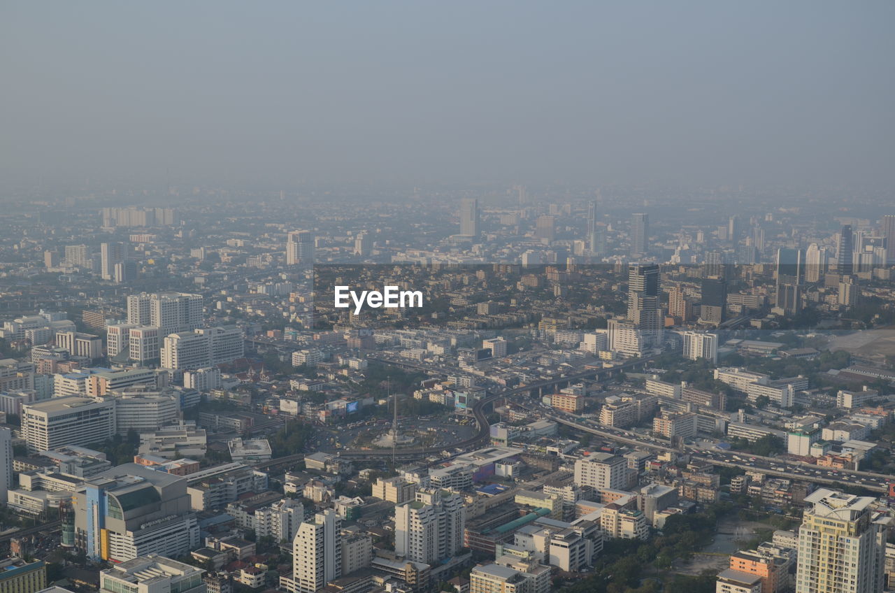 HIGH ANGLE VIEW OF BUILDINGS IN CITY AGAINST SKY