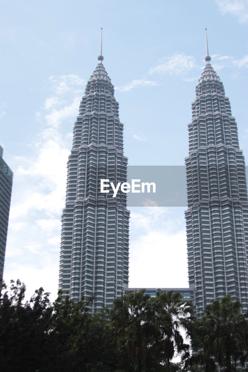 Low angle view of buildings against cloudy sky