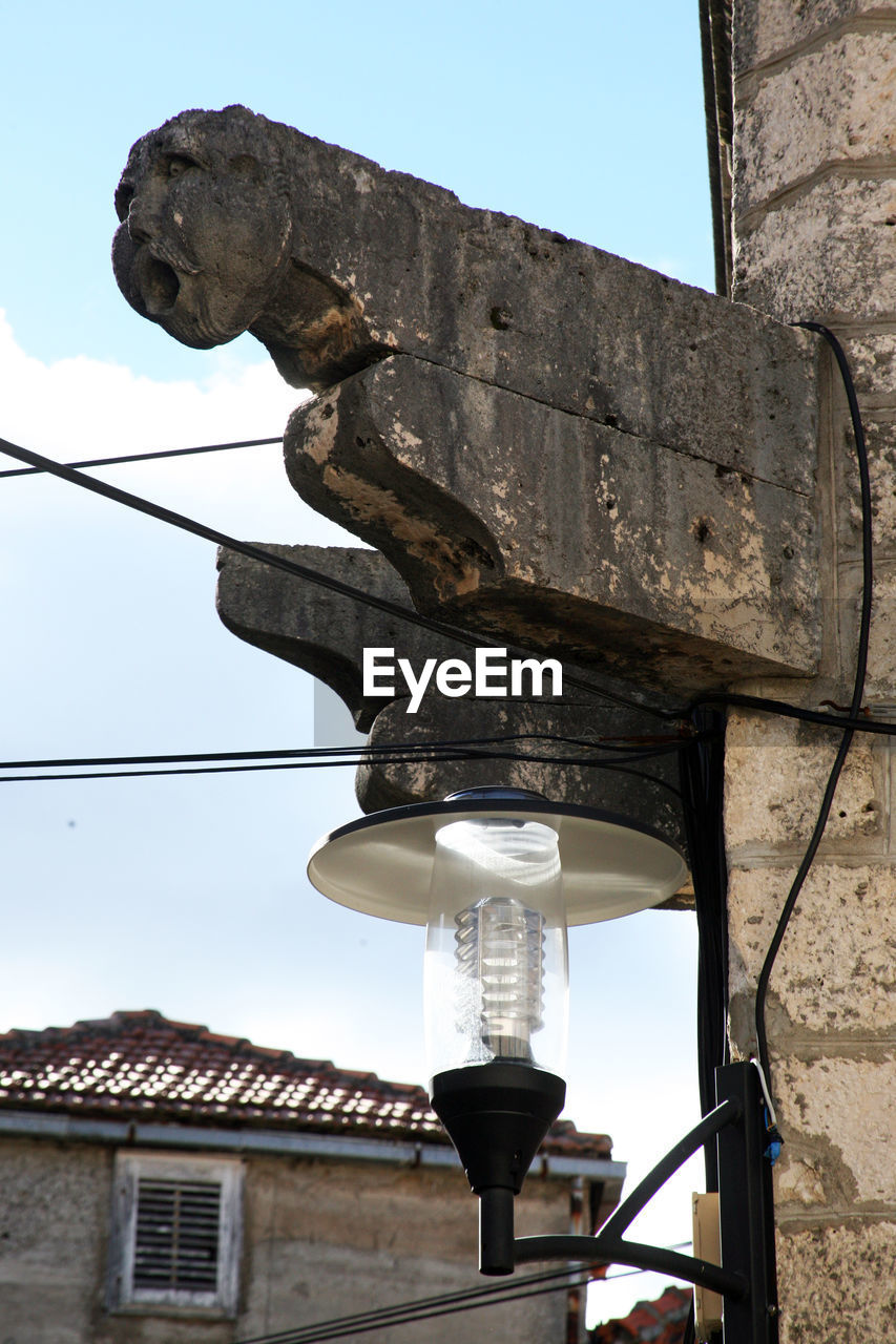 LOW ANGLE VIEW OF STATUE PERCHING ON BUILDING