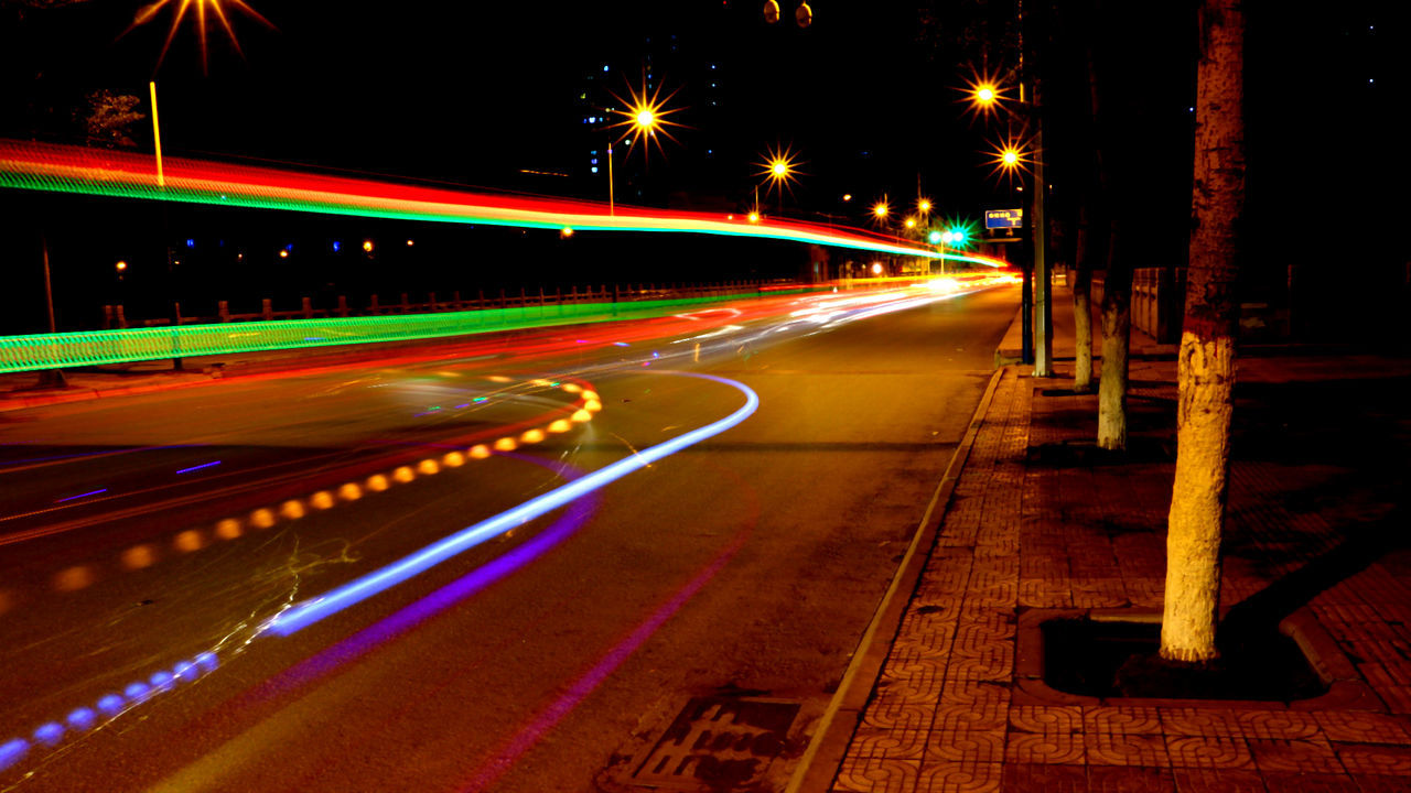 LIGHT TRAILS ON STREET AT NIGHT