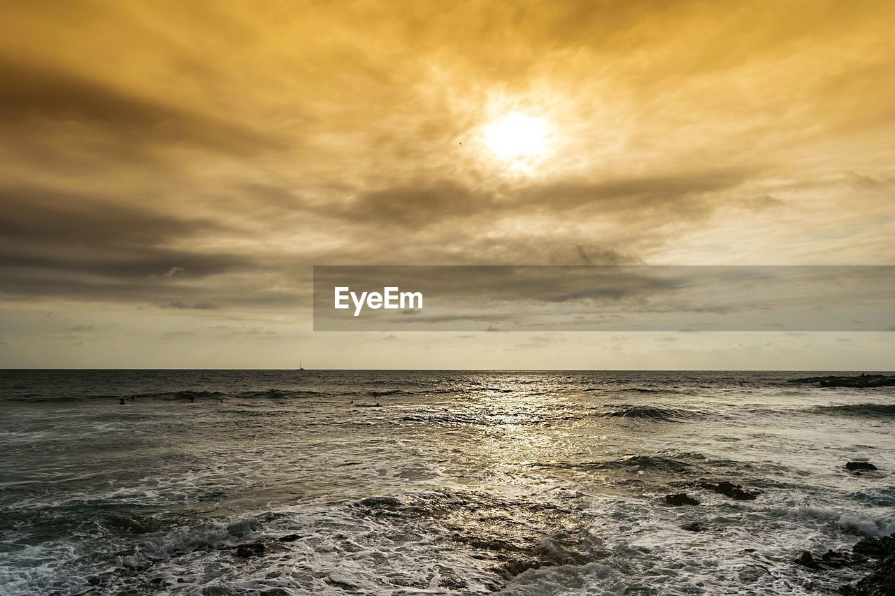 SCENIC VIEW OF BEACH AGAINST SKY AT SUNSET