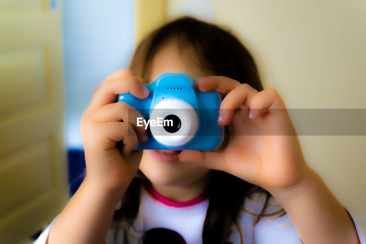 PORTRAIT OF A GIRL HOLDING CAMERA