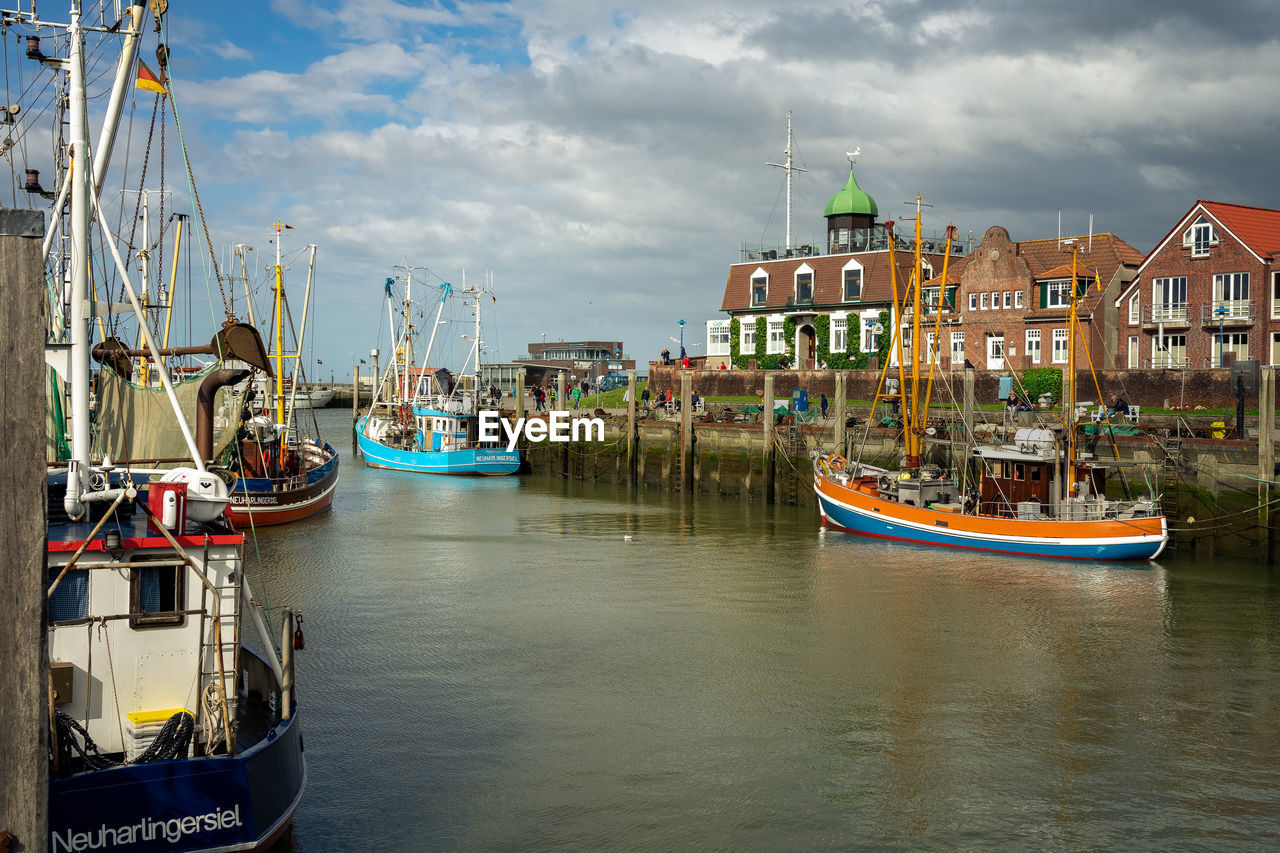 BOATS MOORED AT HARBOR AGAINST SKY