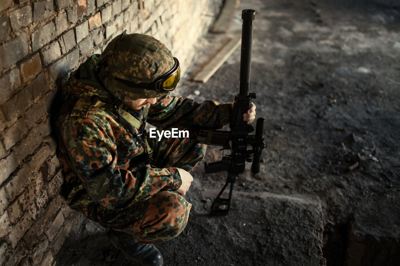A thoughtful soldier, resting from a military operation location of ruins