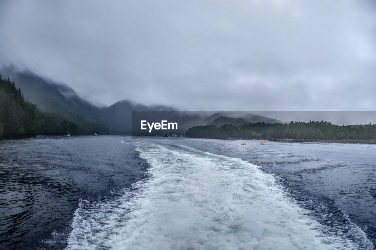 SCENIC VIEW OF SEA AGAINST MOUNTAINS