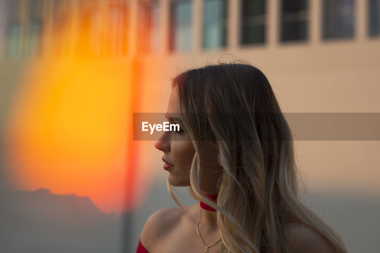 Portrait of young woman looking away outdoors