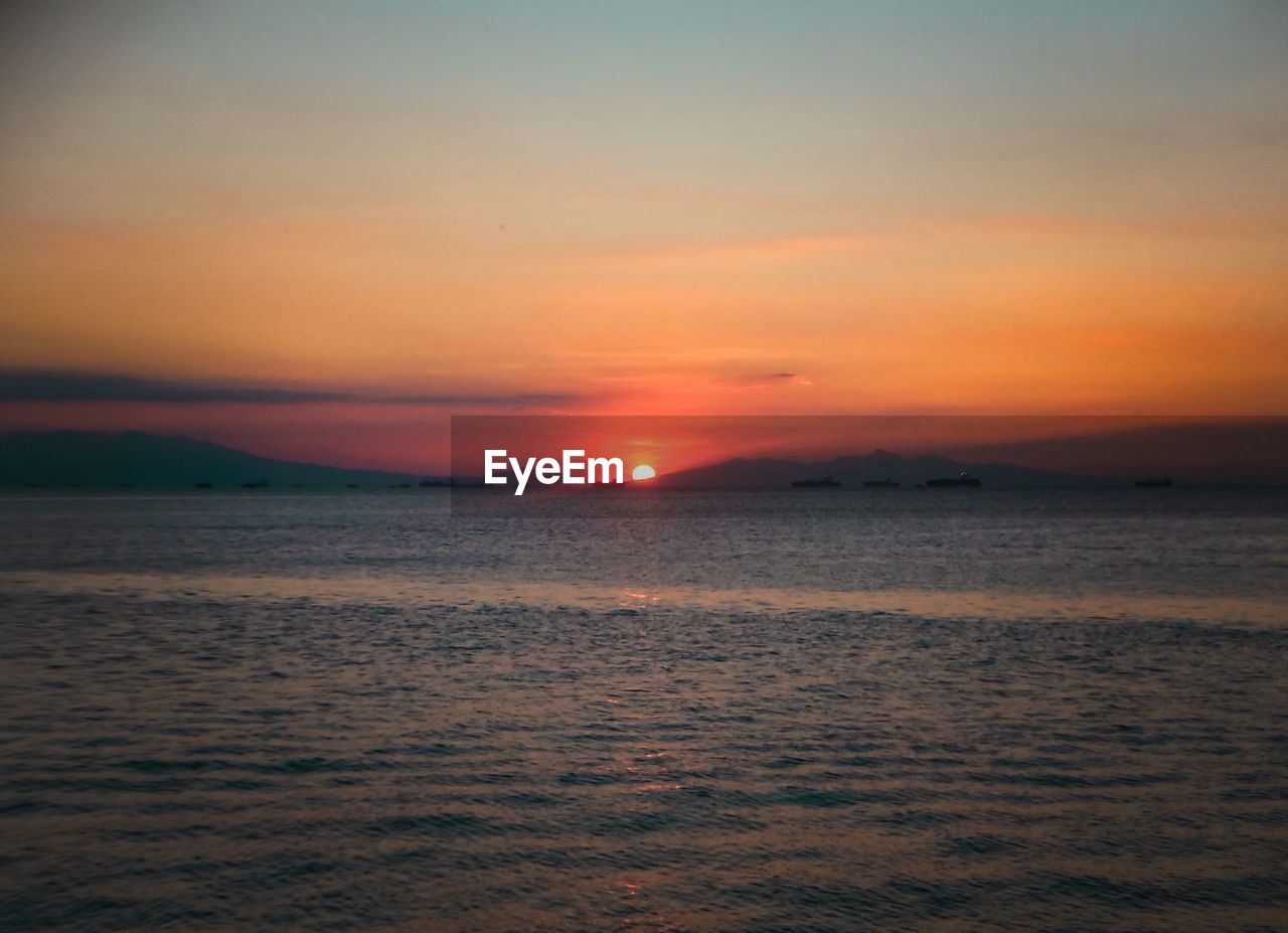 Scenic view of sea against romantic sky at sunset