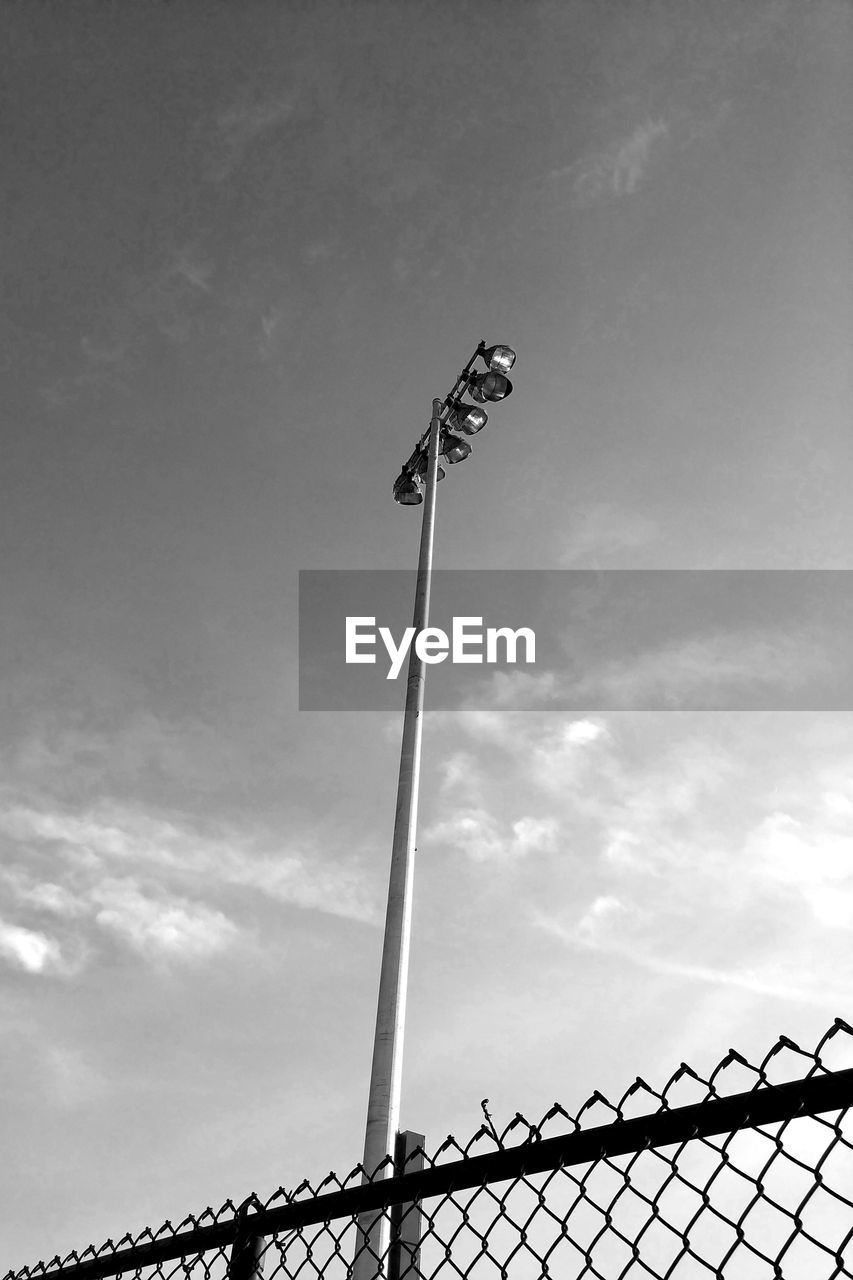 LOW ANGLE VIEW OF FLOODLIGHT ON METAL AGAINST SKY