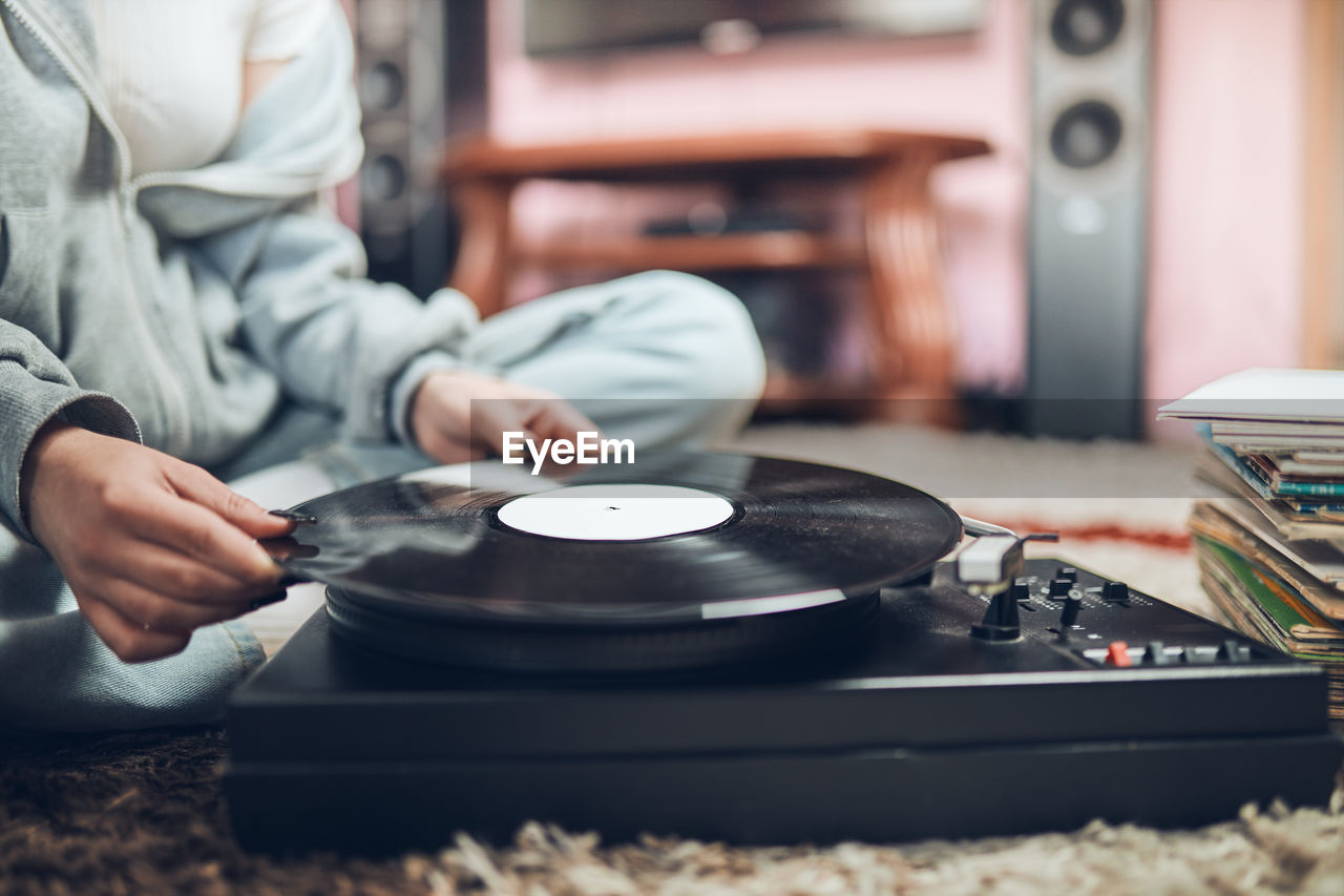 Young woman listening to music from vinyl record player. retro and vintage style. hobby and passion