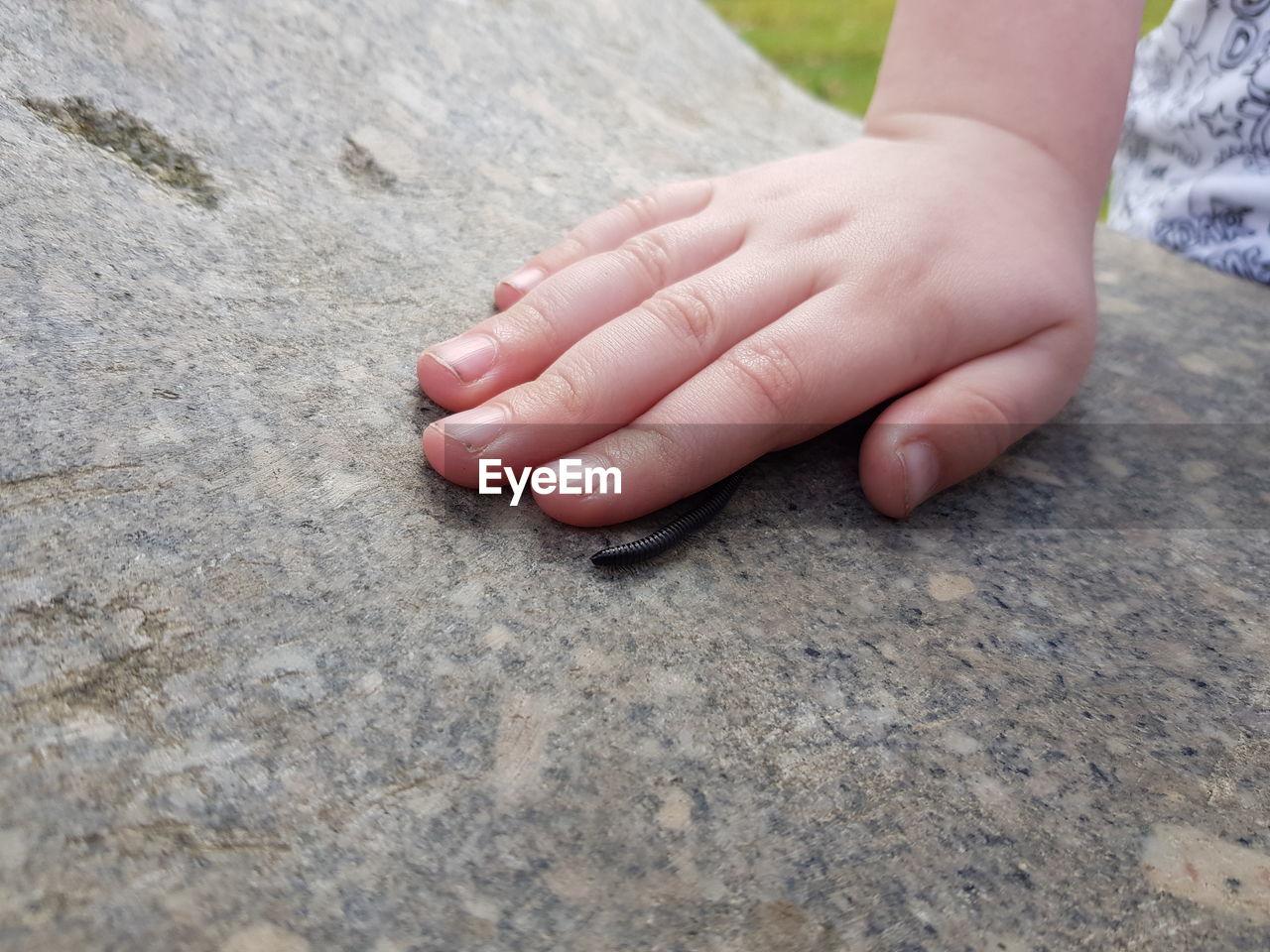 Cropped hand of girl on marble