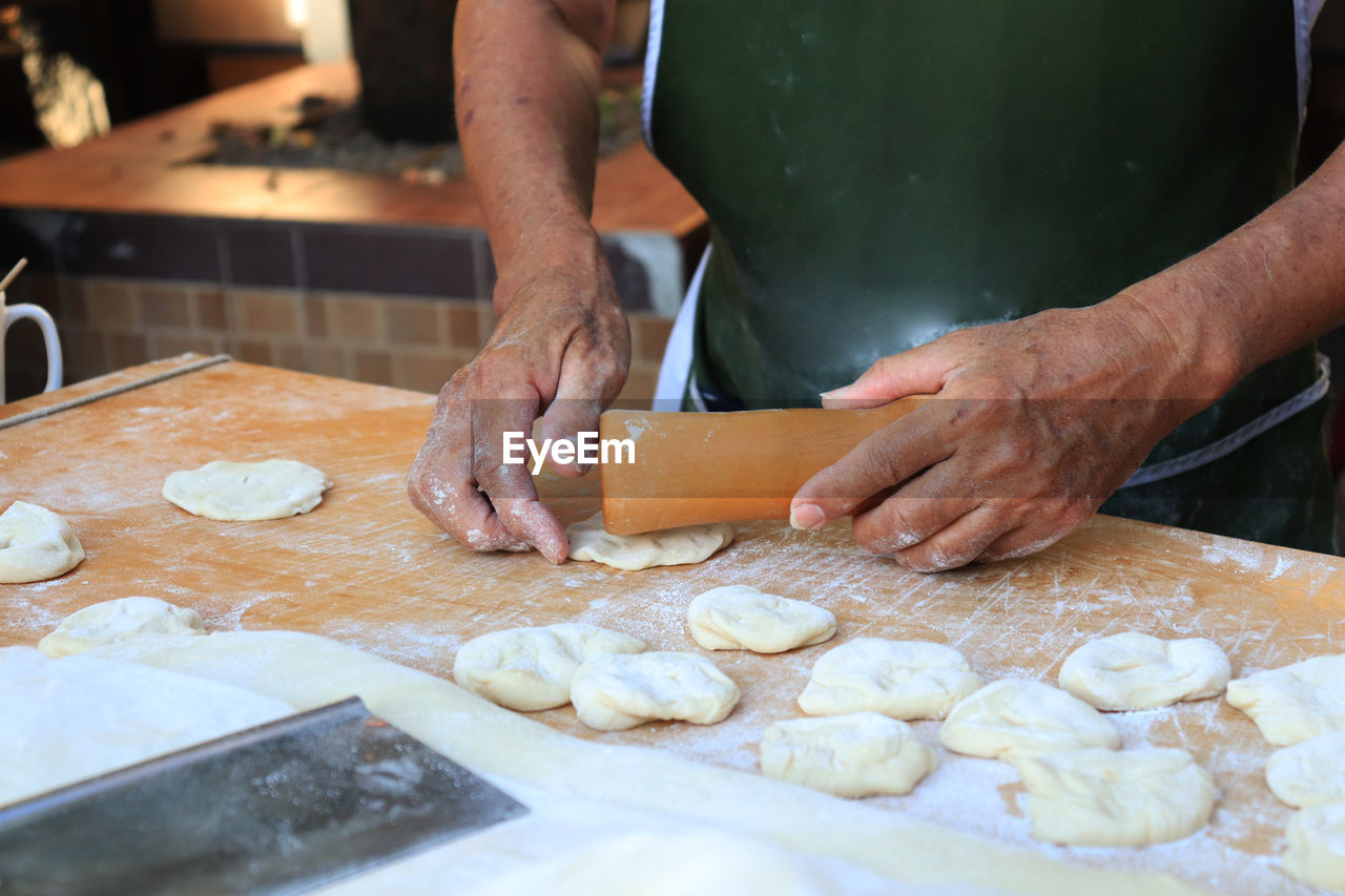 Midsection of man preparing food in kitchen