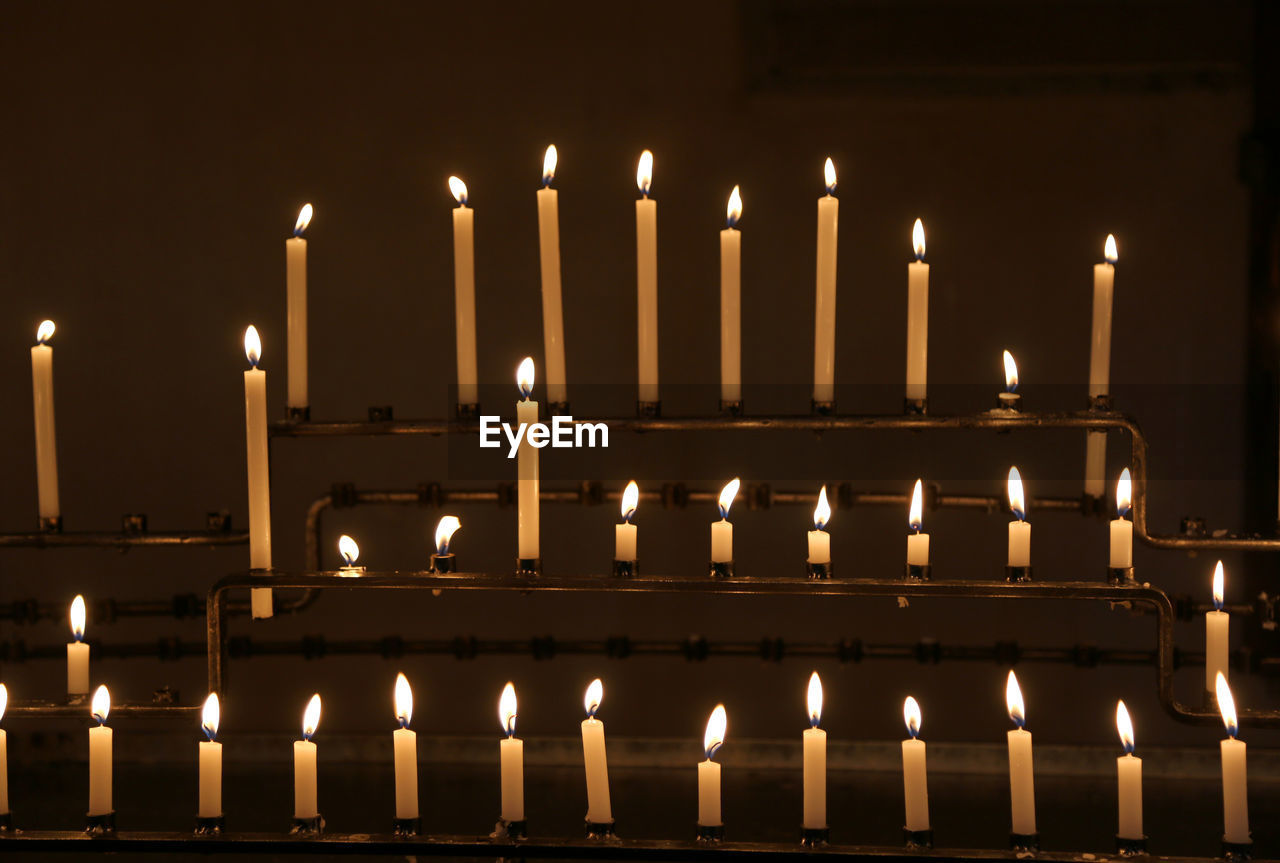Many candles with flames during religion mass in the church
