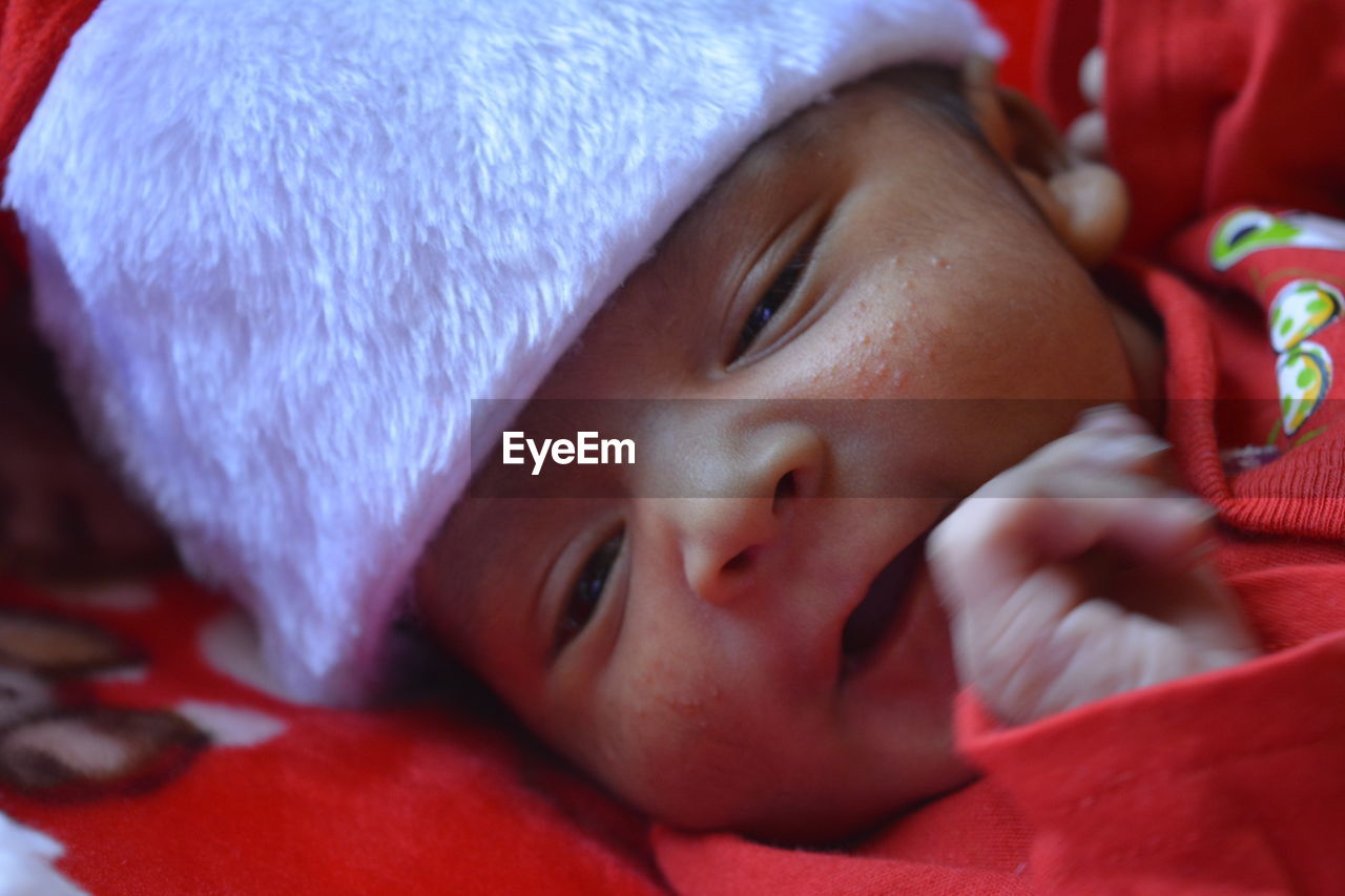 Close-up of cute baby boy lying on bed