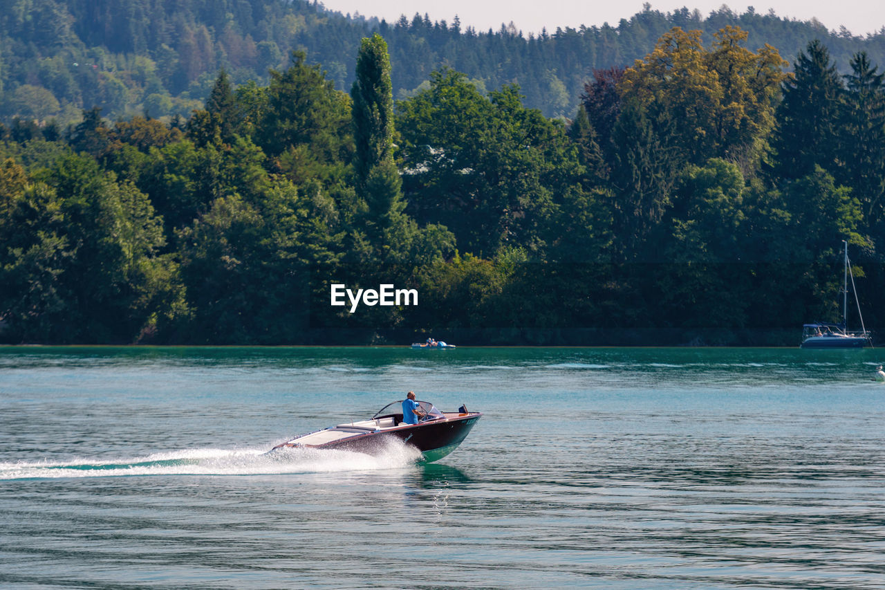 MAN ON BOAT AGAINST SEA