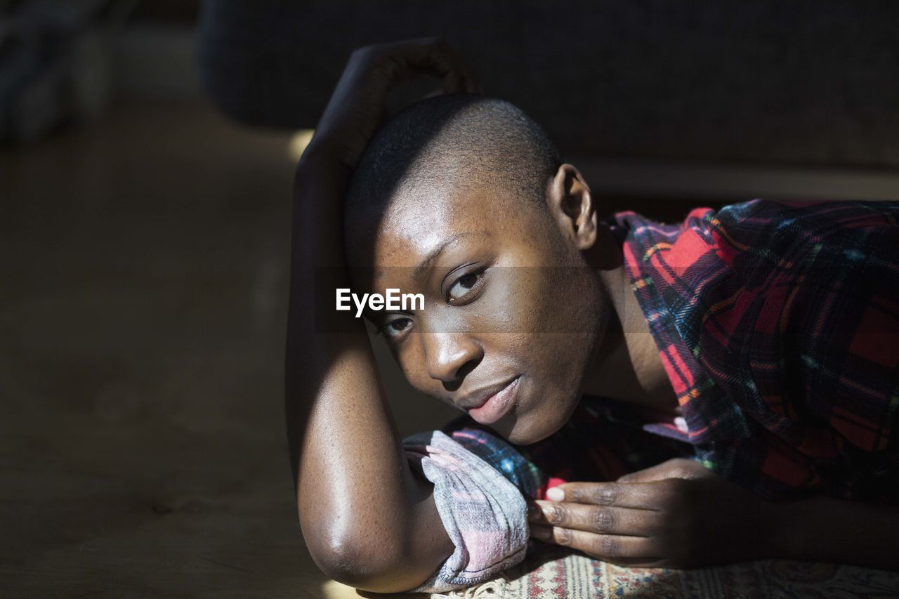 Beautiful young woman relaxing in beam of sunlight