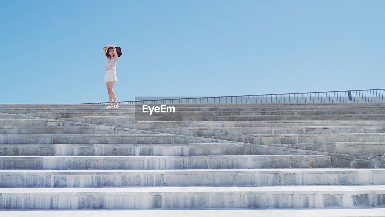 Full length of woman standing on steps